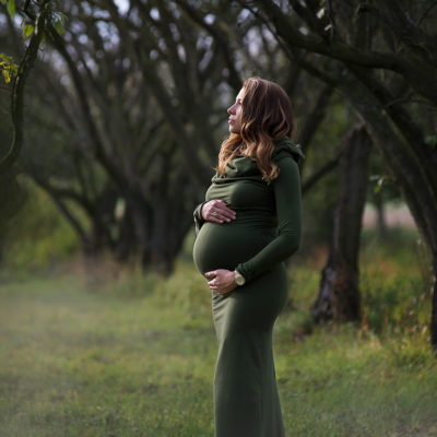 Portret kobiety w ciąży w sadzie późnym latem